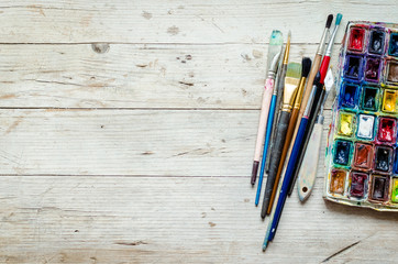 Artist paint brushes on the wooden background