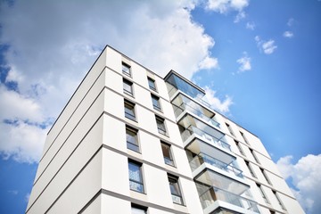 Fototapeta premium Modern apartment buildings on a sunny day with a blue sky. Facade of a modern apartment building