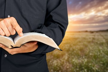 Man reading old heavy book on background