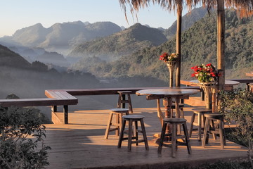 view of desk and chair in tea shop with green mountain background, Rai Cha 2000 Tea farm...