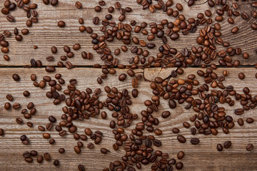 wooden weathered table with scattered roasted coffee beans