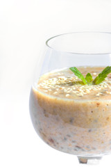 Vegetarian healthy banana smoothie in glass with mint isolated on white background