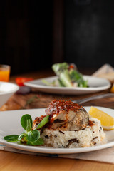 Close up of a steamed fish in tomato gravy with wild boiled rice for diet dinner in a cafe