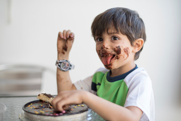 Dirty kid eating chocolate pie