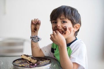 Dirty kid eating chocolate pie