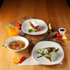Steak with mashed potatoes, light vegetable soup with meatballs and vegetarian spring roll for healthy diet lunch, placed on a wooden table with sidelight