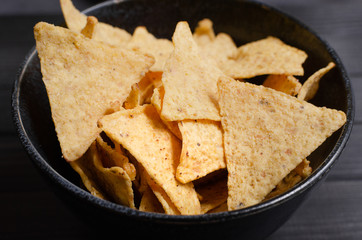 Mexican nachos with sauces on dark background