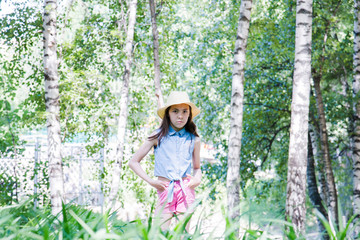 portrait of girl posing in hat in park in summer time. summer vacation