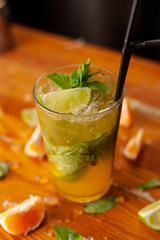 Refreshing seasonal citrus lemonade with ice, lime, orange, juice and sparkling water on a bar counter