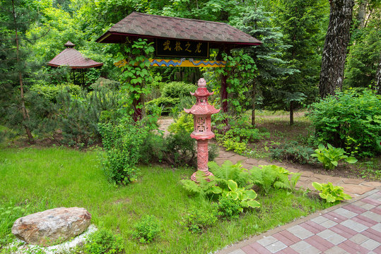 summer chinese garden with yellow pathway, tea pagoda on green summer background