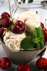 Cherry and vanilla ice cream scoop with fresh cherries and mint on a rustic background