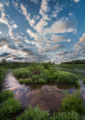 Reflection of clouds in the water. Early morning on the Ugra river.