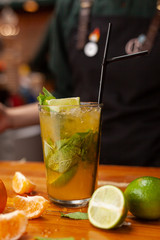 Seasonal citrus lemonade on a the bar counter, decorated with ingredients: lime, orange and lemon