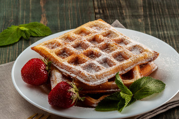 Viennese waffles with strawberries and mint are on the platter