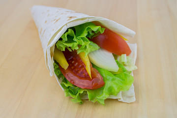 Vegetable roll in pita bread, tomatoes, onions, paprika greens, raw vegetables, snack. Vegan vegetarian tasty and healthy low-calorie food