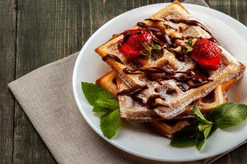 Viennese waffles with strawberries and mint are on the platter