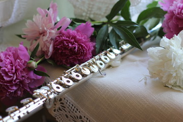 silver flute with a bouquet of pink peonies, color photography