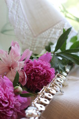 silver flute with a bouquet of pink peonies, color photography © olga_63