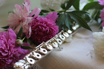 silver flute with a bouquet of pink peonies, color photography