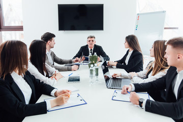 Business conference in office center. Boss with his workers.