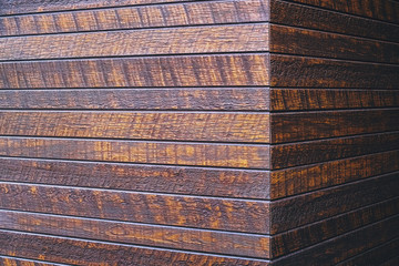The surface of the wooden dies of dark color in natural lighting, wooden wall