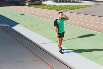 Obraz premium full length view of mixed race sportsman standing at stadium