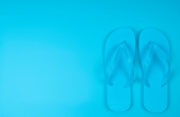 Beach flip-flops on the blue background. Summer is concept.
