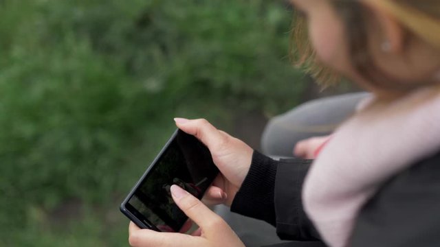 Girl watches photos on her mobile phone - travel photography