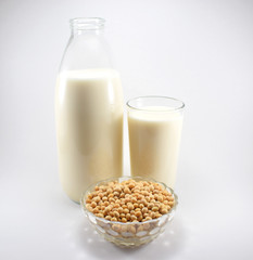 Botella y vaso de leche de soja y bol con granos de soja 