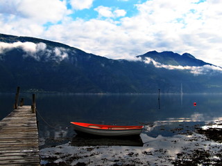 Abandoned boat near wooden pier on a Norwegian lake