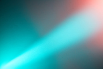 A light turquoise diagonal beam of light separates the turquoise and pink background