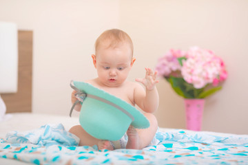 Beautiful and cute baby sitting on bed.