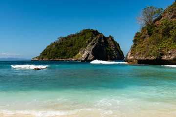 Fototapeta na wymiar View of tropical beach, sea rocks and turquoise ocean, blue sky. Atuh Beach, Nusa Penida, Indonesia.