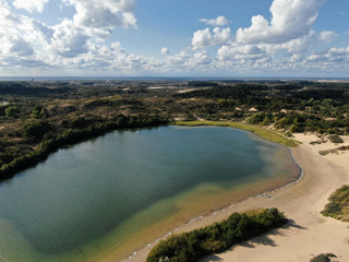 Aerial of clear dune lake with north sea in the background