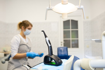 a modern photopolymerization lamp for light fillings in the dental office, on a blurred background