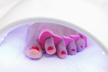 Pedicure foot and nails treatment with  UV lamp