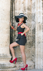 Pretty lady wearing fashionable clothes and red high heels shoes at Plaza de la Catedral in Old Havana, Cuba