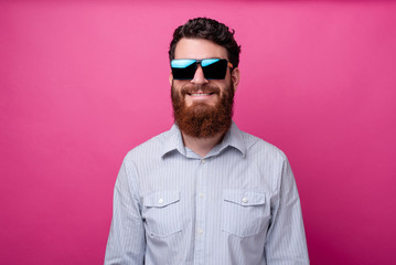 Portrait of cheerful bearded man in casual wearing sunglasses