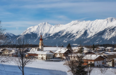 Austrian village Tulfes near Innsbruck and Heiliger Apostel Thomas church in winter day.