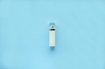  White bottle of perfume with a transparent cap  on a blue background. soft focus. copy space. isolated.