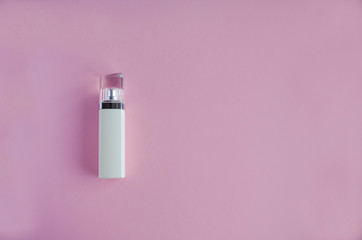 White bottle of perfume on a pink background. soft focus. copy space.