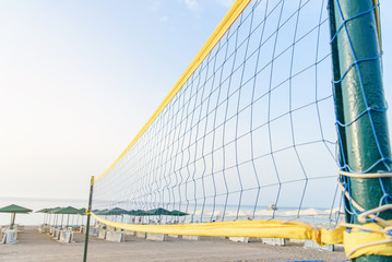 A volleyball net on the beach with a clear and sunny sky