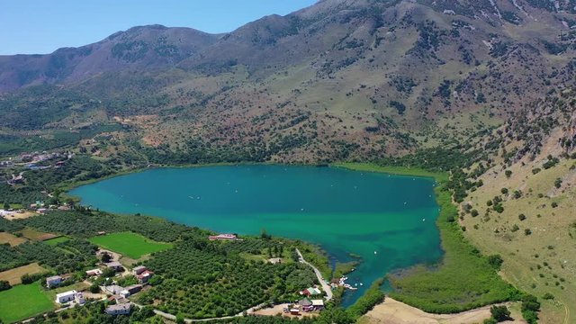 Aerial drone panoramic video of famous natural lake of Kournas with amazing colours and unique nature surrounded by mountains, Chania prefecture, Crete island, Greece