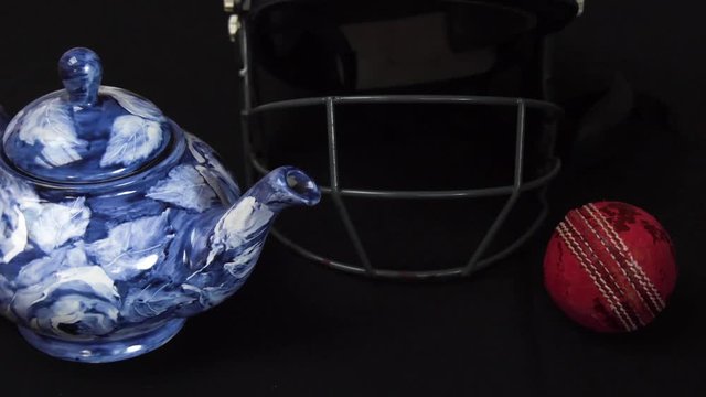 Cricket ball rolls into frame alongside a teapot and cricket helmet to celebrate the Cricket World Cup in England and Wales.