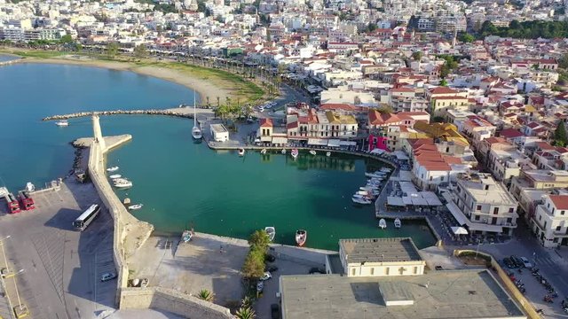 Aerial drone video of unique old picturesque Venetian port with old lighthouse in the heart of famous city of Rethymno at sunset, Crete island, Greec