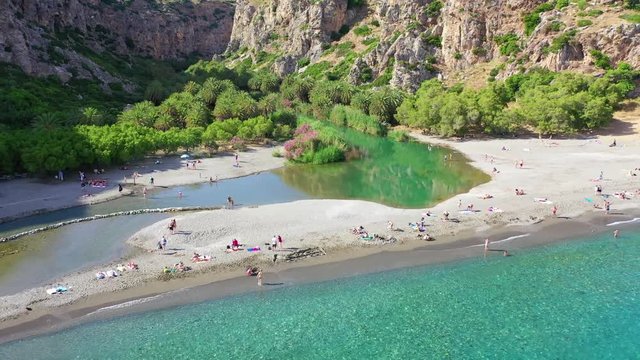 Aerial drone video of Preveli paradise palm beach and lagoon with Palm trees in the South from city of Rethymno, Crete, Greece
