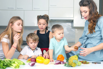 mother with children preparing vegetables in the kitchen.
