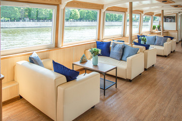 The interior of the urban river ship, with a panoramic view of the urban landscape. The concept of tourism, recreation, walking around the city, rest in the city. River transport.