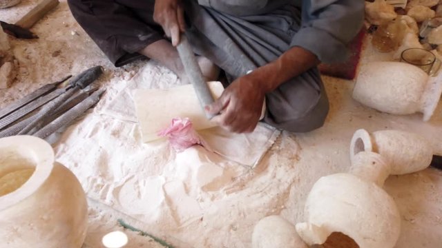 Man Shapes an Alabaster Stone Vase Using a File.