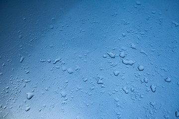 Gotas de água em vidro com fundo azul